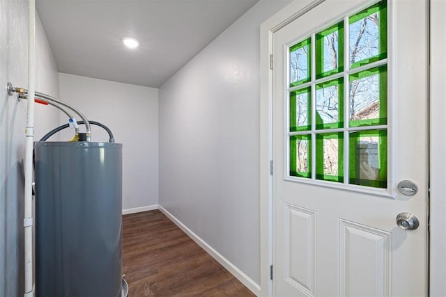 entryway with dark wood-type flooring, gas water heater, and baseboards