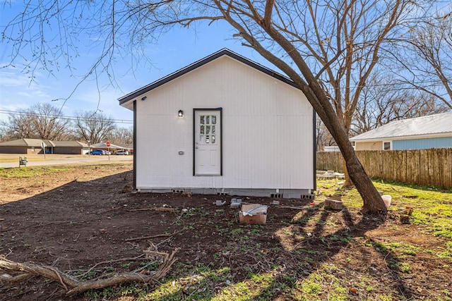 view of outbuilding featuring fence and an outdoor structure