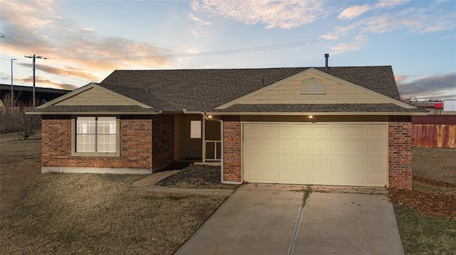 ranch-style house with fence, an attached garage, a shingled roof, concrete driveway, and brick siding