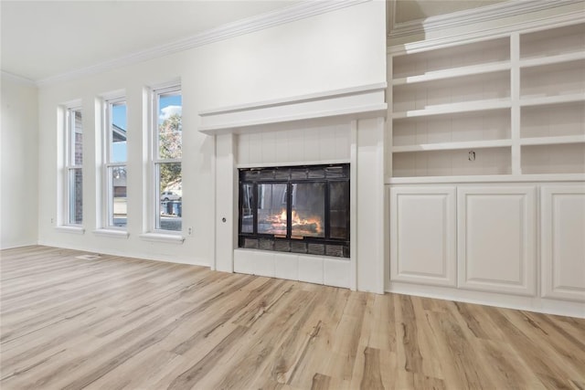 unfurnished living room featuring light wood-type flooring, a multi sided fireplace, and ornamental molding