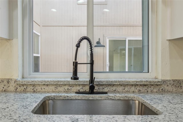 details featuring light stone countertops and a sink