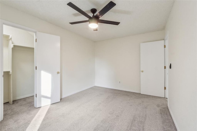 carpeted spare room with baseboards, a textured ceiling, and a ceiling fan