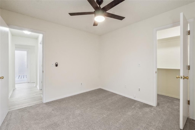 empty room featuring carpet flooring, a ceiling fan, and baseboards