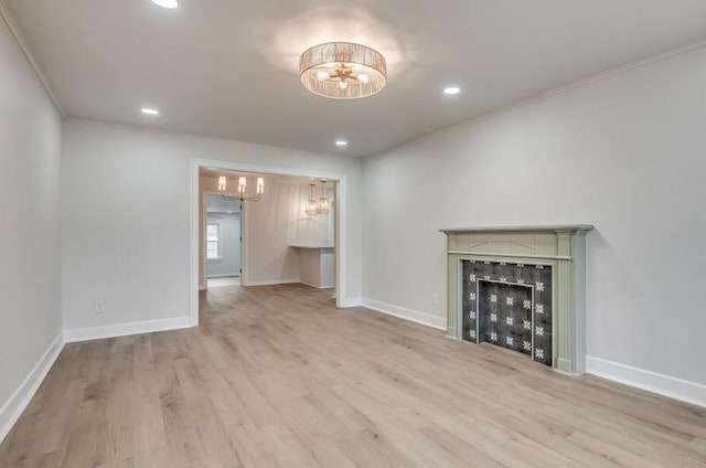 unfurnished living room with a chandelier, a fireplace, wood finished floors, and baseboards