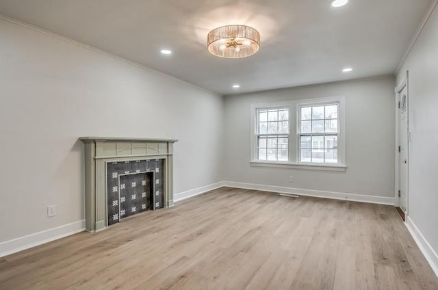 unfurnished living room with crown molding, a fireplace, recessed lighting, wood finished floors, and baseboards