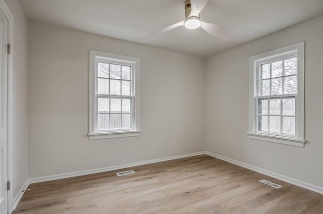 unfurnished room featuring light wood-type flooring, visible vents, ceiling fan, and baseboards