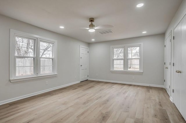 foyer with a healthy amount of sunlight, light wood-type flooring, visible vents, and baseboards