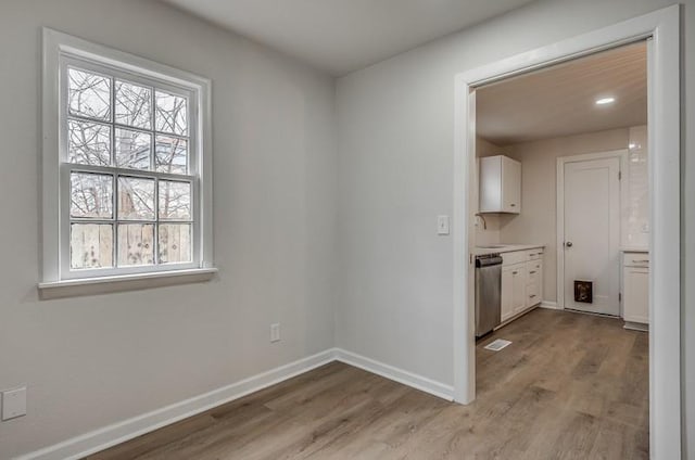 interior space with light wood-style floors, baseboards, and a sink