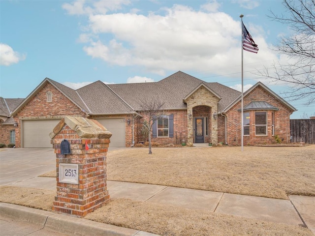 view of front of property featuring a garage, driveway, a shingled roof, and brick siding