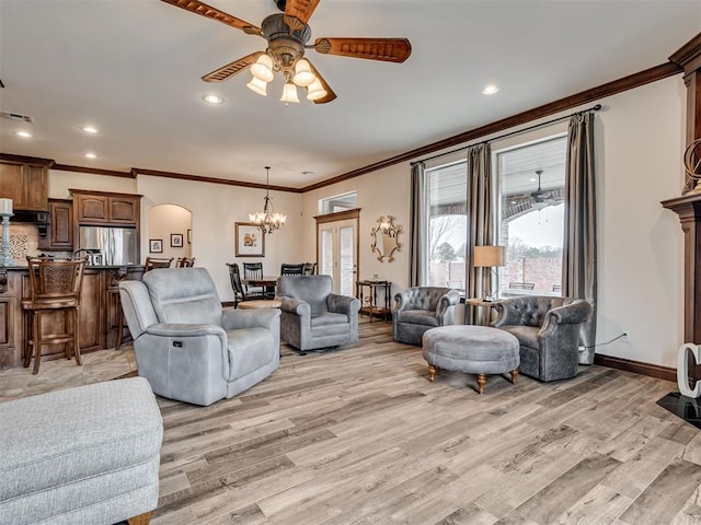 living room with light wood-type flooring, visible vents, baseboards, and ceiling fan with notable chandelier