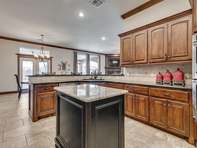 kitchen featuring visible vents, a sink, a peninsula, and decorative backsplash