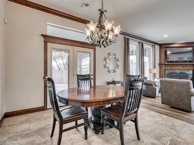 dining space featuring a healthy amount of sunlight, a fireplace, visible vents, and ornamental molding