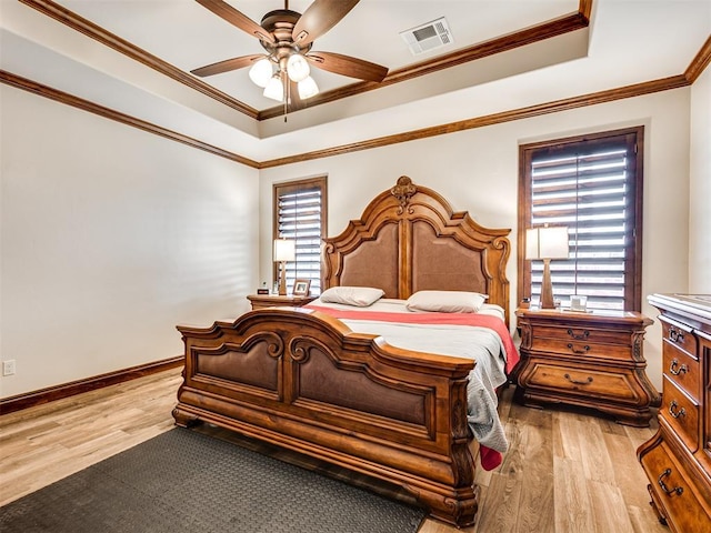 bedroom with light wood finished floors, ornamental molding, and visible vents