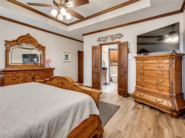 bedroom featuring light wood-style floors, ceiling fan, a tray ceiling, and crown molding