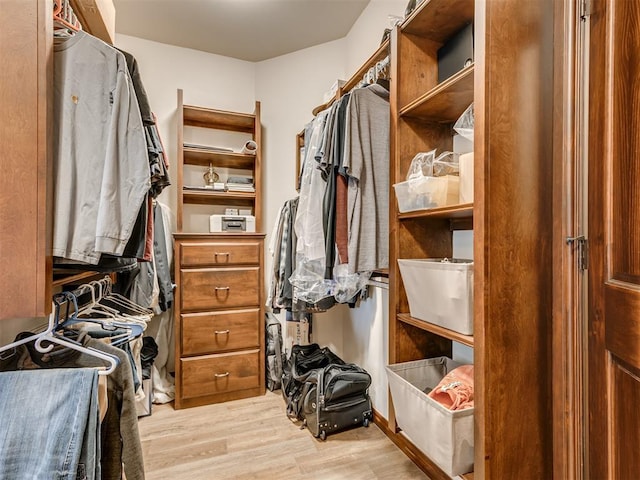 walk in closet with light wood-style flooring