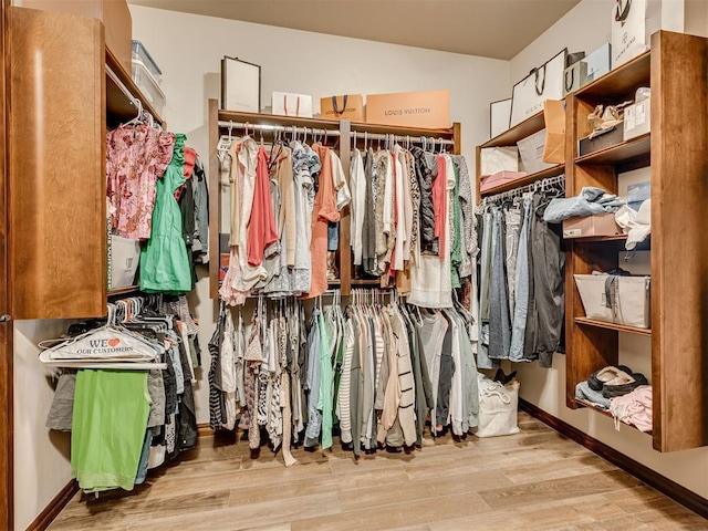 spacious closet featuring lofted ceiling and wood finished floors