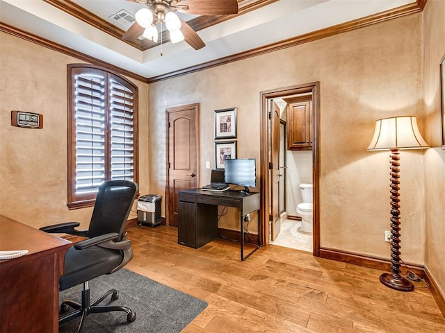 office featuring visible vents, ornamental molding, a ceiling fan, light wood-type flooring, and baseboards