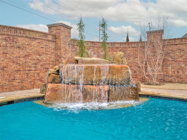 view of pool featuring fence