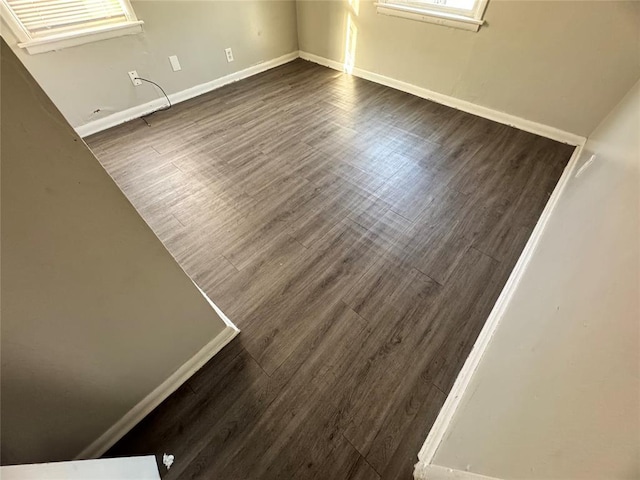 empty room featuring dark wood-style floors and baseboards