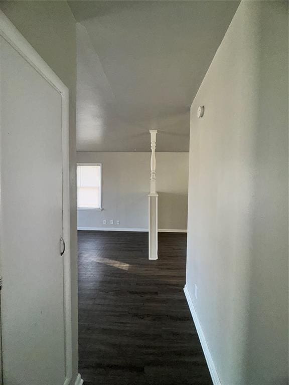 hall with baseboards and wood finished floors