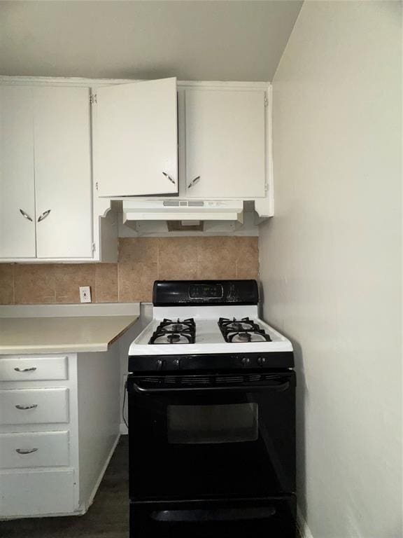 kitchen with white cabinets, light countertops, under cabinet range hood, backsplash, and gas stove