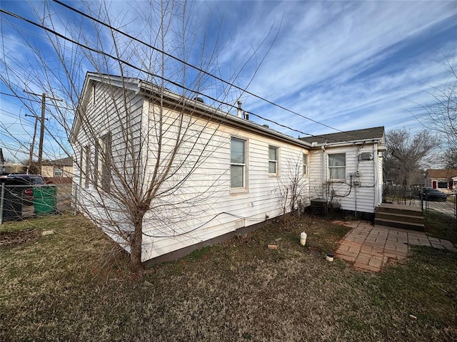 rear view of house with a yard and fence