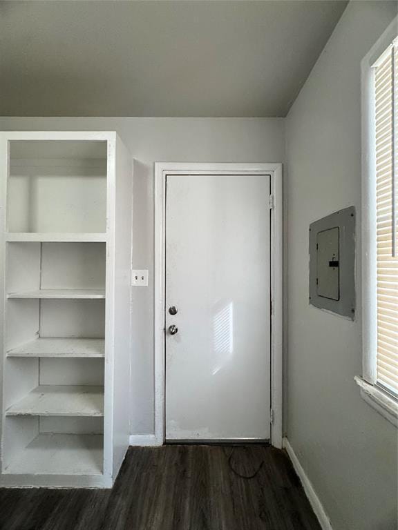 doorway to outside featuring dark wood-style floors, electric panel, and baseboards