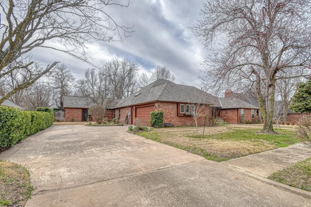 view of property exterior featuring a garage, a lawn, concrete driveway, and brick siding