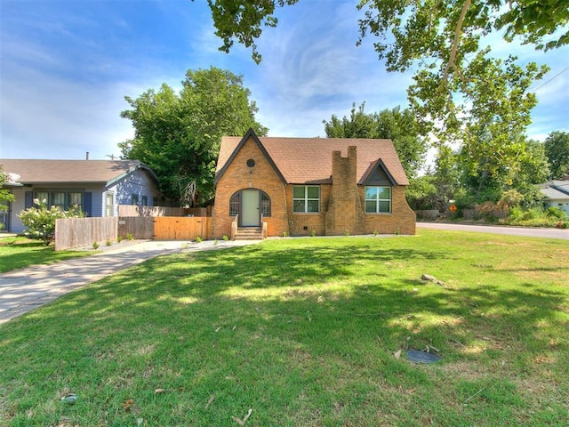 view of front of house with entry steps, brick siding, fence, crawl space, and a front yard