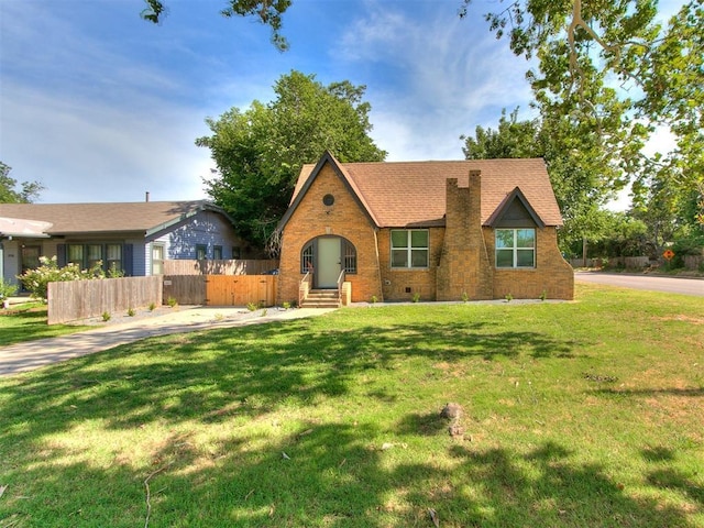 view of front of home with crawl space, a front yard, fence, and brick siding