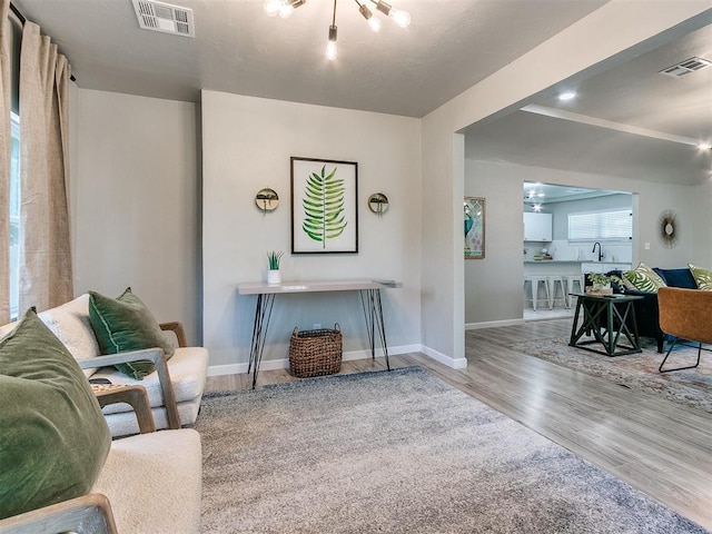 living room featuring wood finished floors, visible vents, and baseboards