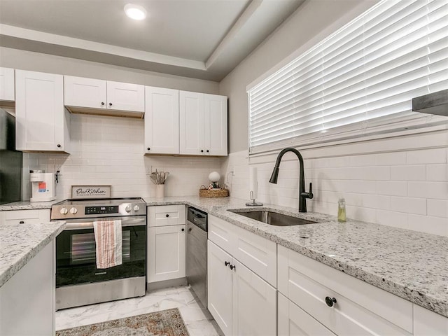 kitchen featuring marble finish floor, appliances with stainless steel finishes, white cabinets, and a sink