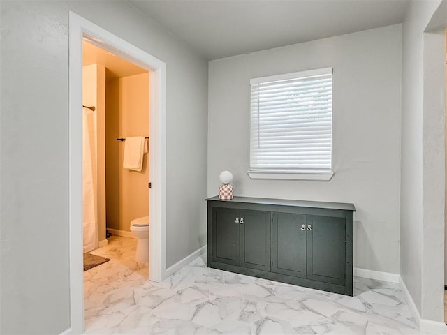 full bath featuring marble finish floor, toilet, and baseboards