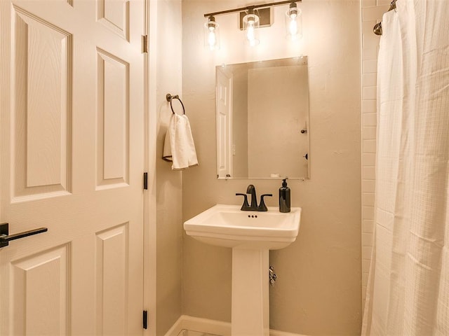 bathroom with curtained shower and a sink