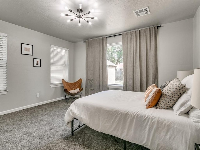 carpeted bedroom with a textured ceiling, visible vents, and baseboards