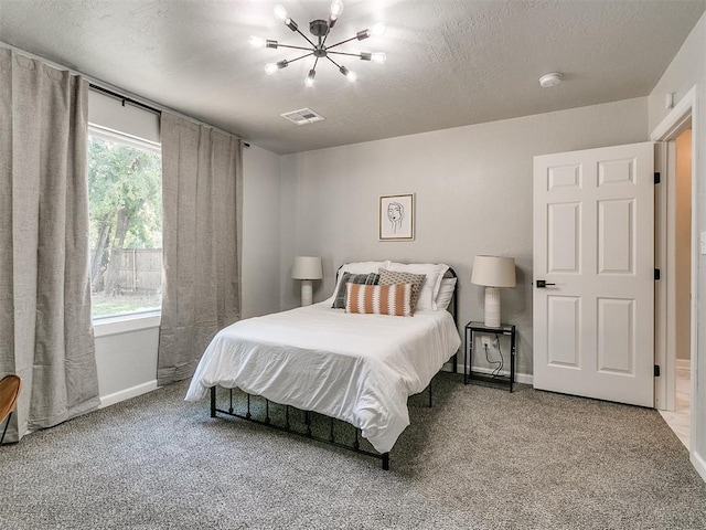 bedroom featuring a textured ceiling, carpet floors, visible vents, and baseboards