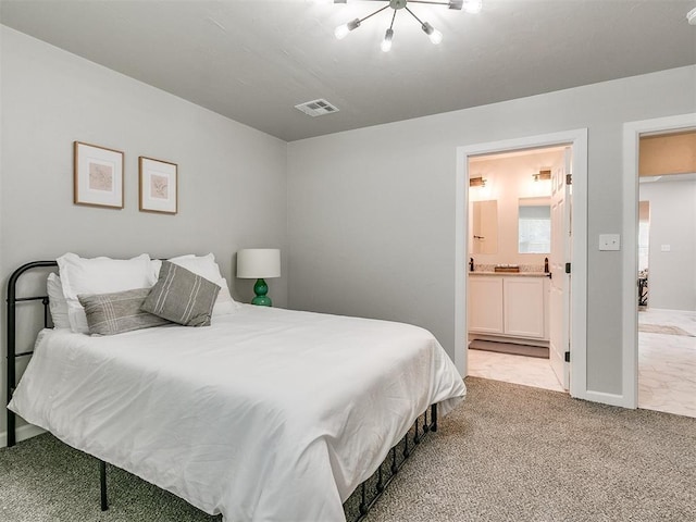 bedroom featuring light carpet, ensuite bath, and visible vents