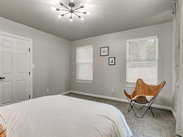 bedroom with baseboards, dark colored carpet, and a textured ceiling