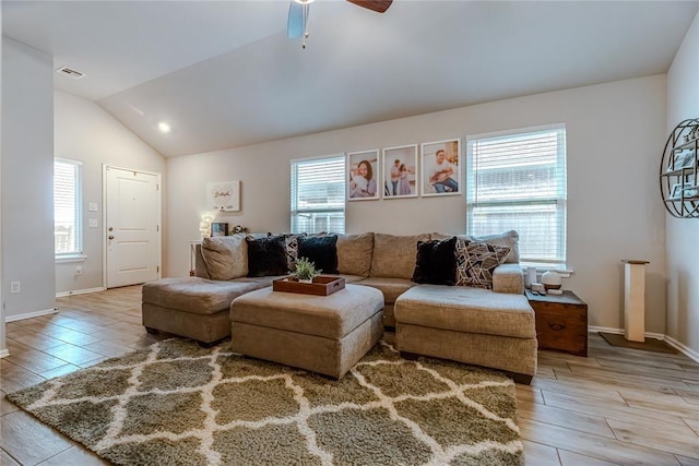 living area featuring vaulted ceiling, light wood-type flooring, visible vents, and baseboards