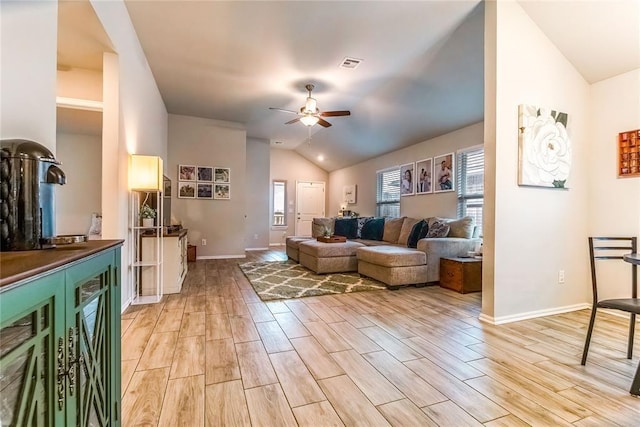 living room with wood tiled floor, a healthy amount of sunlight, visible vents, and lofted ceiling