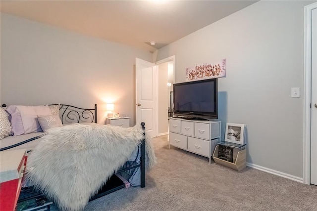 bedroom with light colored carpet and baseboards