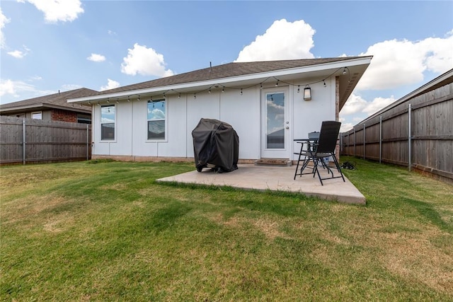 back of property featuring a yard, a patio, and a fenced backyard