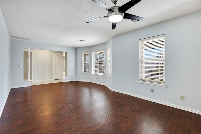 empty room featuring ceiling fan, dark wood-style flooring, a textured ceiling, and baseboards