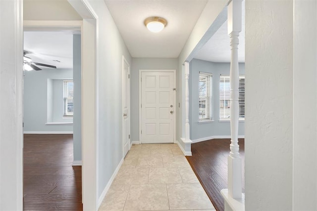 entryway with light wood finished floors, ceiling fan, and baseboards