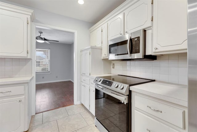 kitchen featuring light tile patterned floors, white cabinets, a ceiling fan, appliances with stainless steel finishes, and light countertops