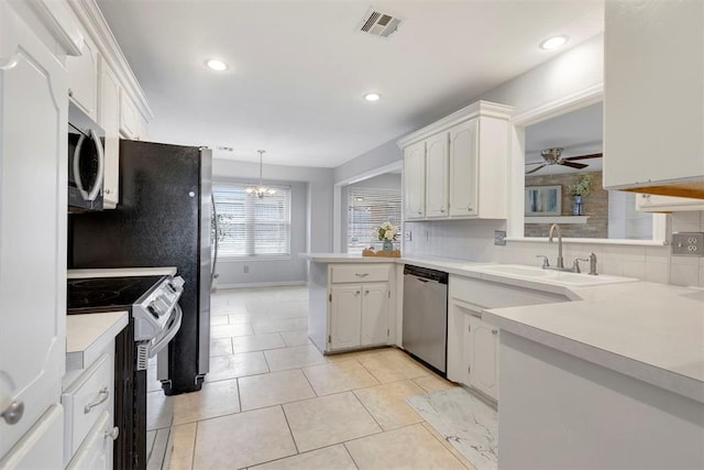 kitchen featuring tasteful backsplash, visible vents, appliances with stainless steel finishes, a sink, and a peninsula