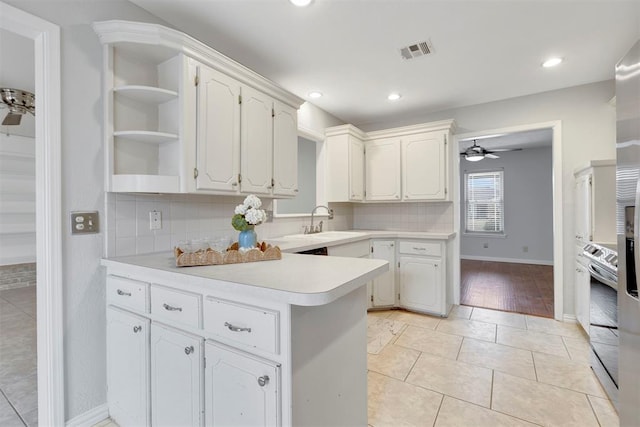 kitchen with ceiling fan, a peninsula, visible vents, light countertops, and open shelves