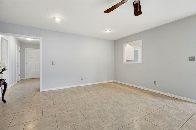 spare room with ceiling fan, light tile patterned flooring, and baseboards