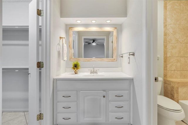 bathroom featuring toilet, tile patterned flooring, walk in shower, and vanity