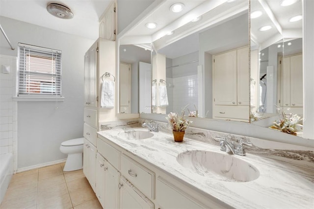 full bathroom featuring toilet, double vanity, a sink, and tile patterned floors